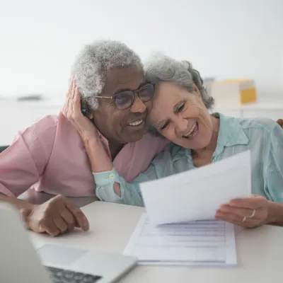 Gelukkig ouder koppel dat papieren bekijkt