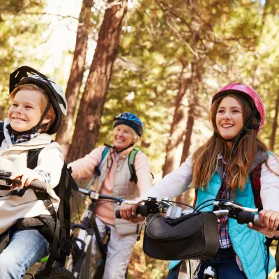 Grootouders met hun kleinkinderen op de fiets in het bos