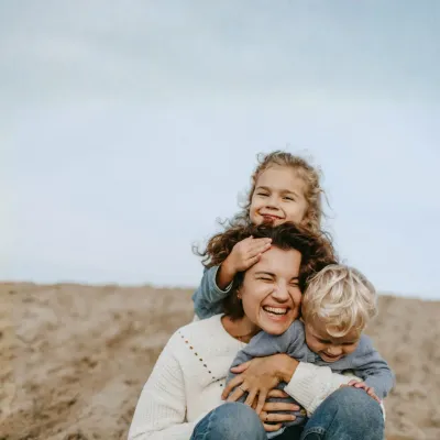 Moeder met twee kinderen aan het strand