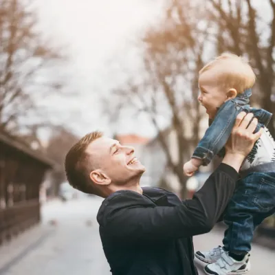 Un papa tient son fils dans les bras.