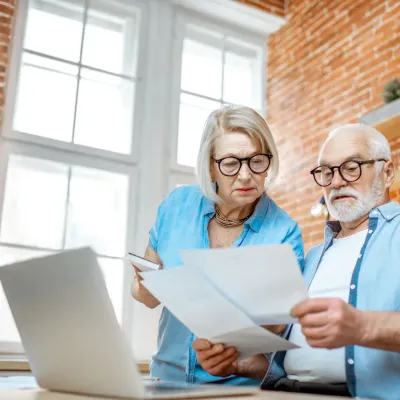 Ouder koppel dat kijkt naar documenten en computer