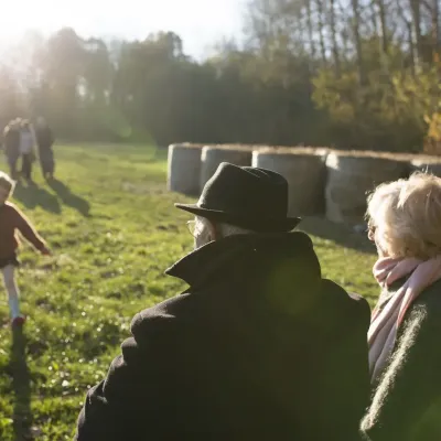 Grootouders kijken naar hun spelend kleinkind