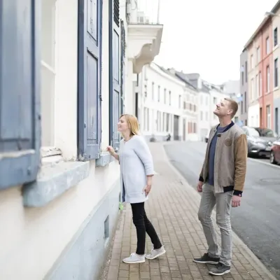 Koppel loopt op straat en kijkt naar de woning