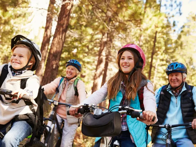 Grootouders met hun kleinkinderen op de fiets in het bos