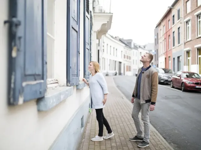 Koppel loopt op straat en kijkt naar de woning