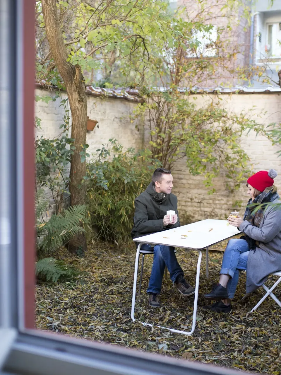 Koppel dat in hun tuin genieten van hun nieuwe woning
